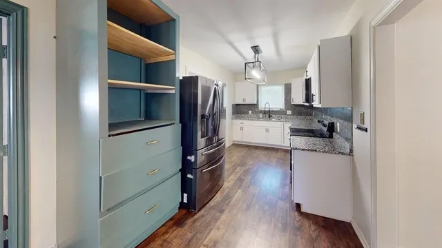a kitchen with a refrigerator a stove and cabinets