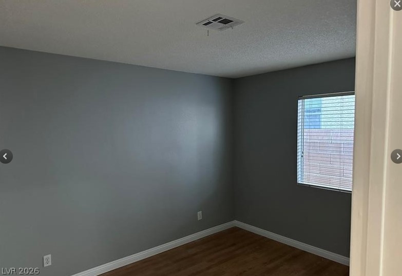 7652 Kalmalii Avenue Las Vegas, NV 89147 - Photo 5 of 9 A well-lit bedroom features durable hardwood flooring and a functional window with blinds.
