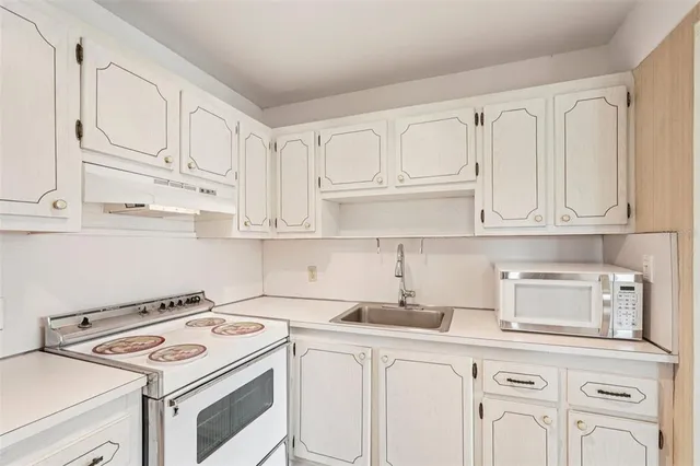 a kitchen with white cabinets and white appliances