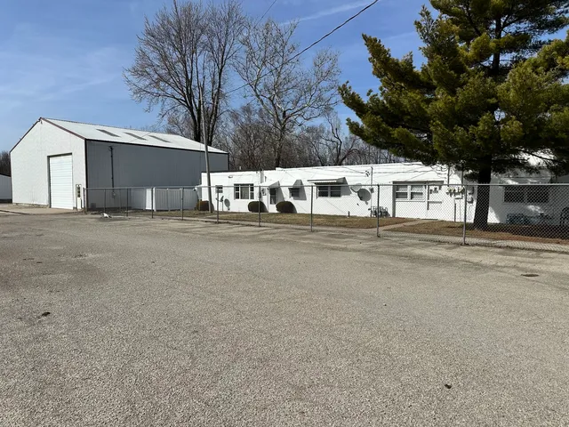 a view of a house with a big yard and large trees