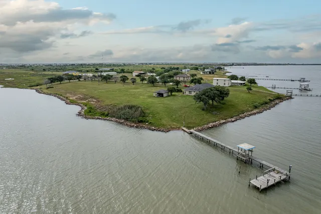 an aerial view of residential houses with outdoor space and lake view
