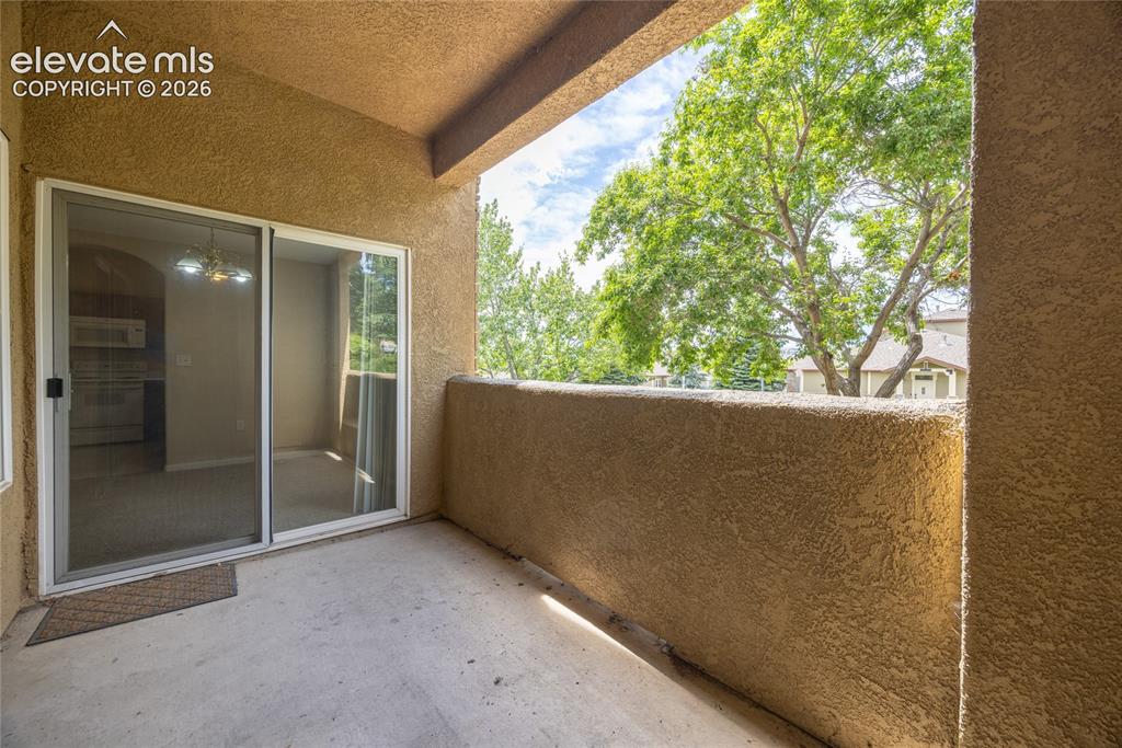 3864 Riviera Grove, Unit 102 Colorado Springs, CO 80922 - Photo 23 of 24 Outdoor balcony featuring a stucco finish, concrete flooring, and a sliding glass door