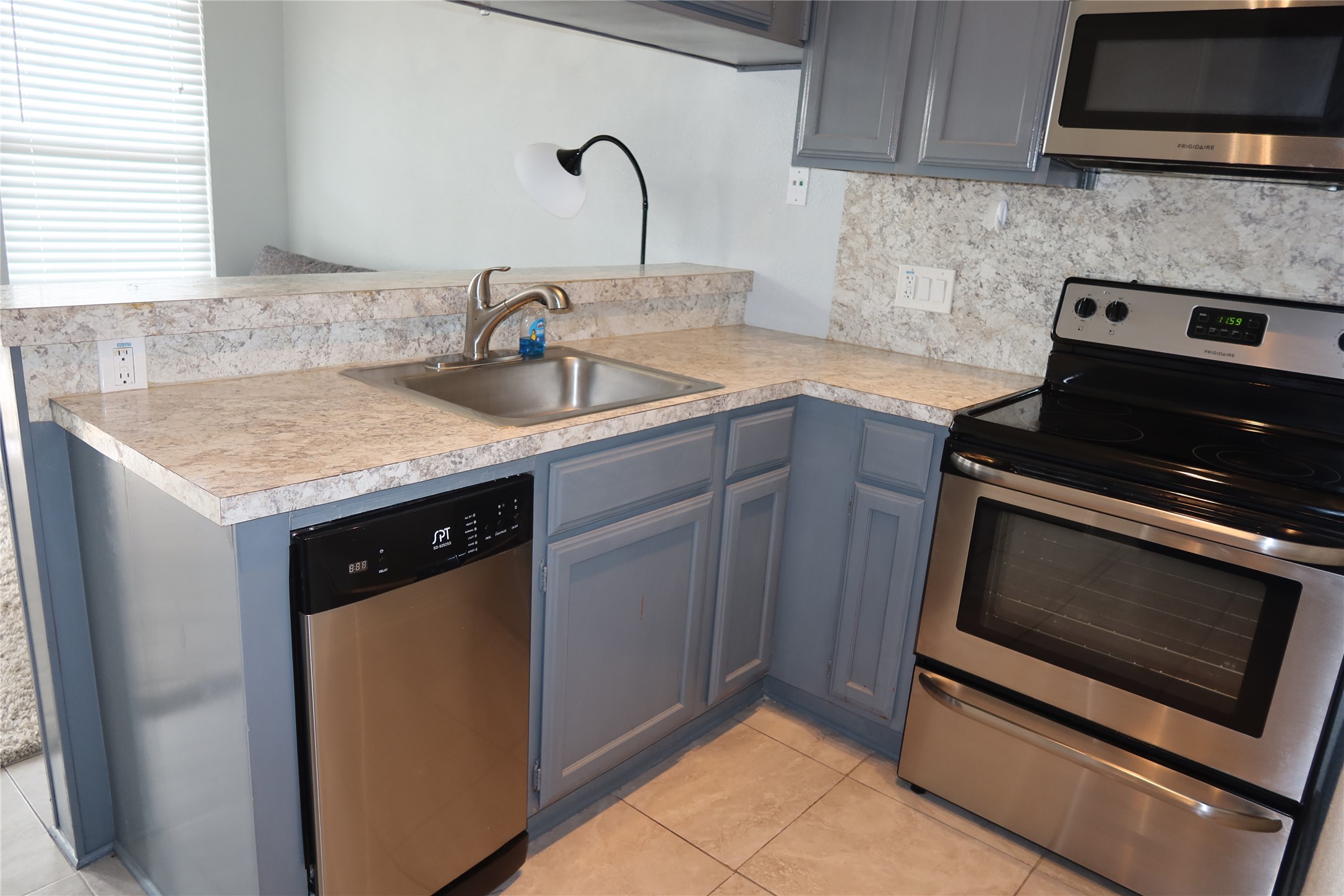 2802 Nueces Street, Unit 306 Austin, TX 78705 - Photo 7 of 17 a kitchen with a sink stove and cabinets