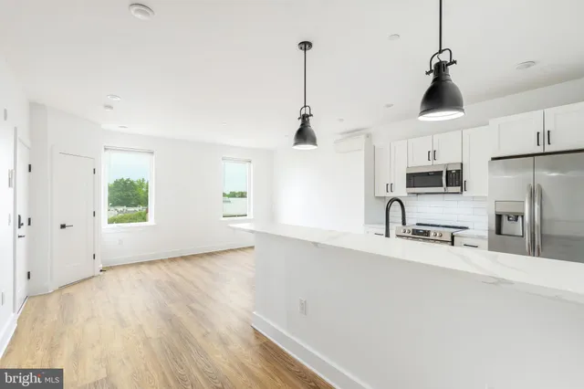 a view of kitchen with sink and refrigerator