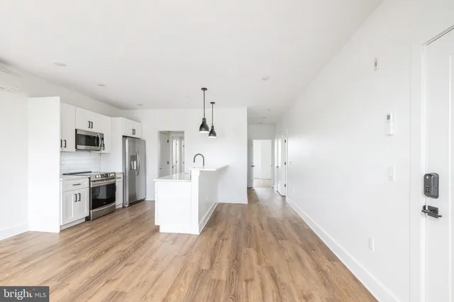 a view of a kitchen with a sink and a refrigerator