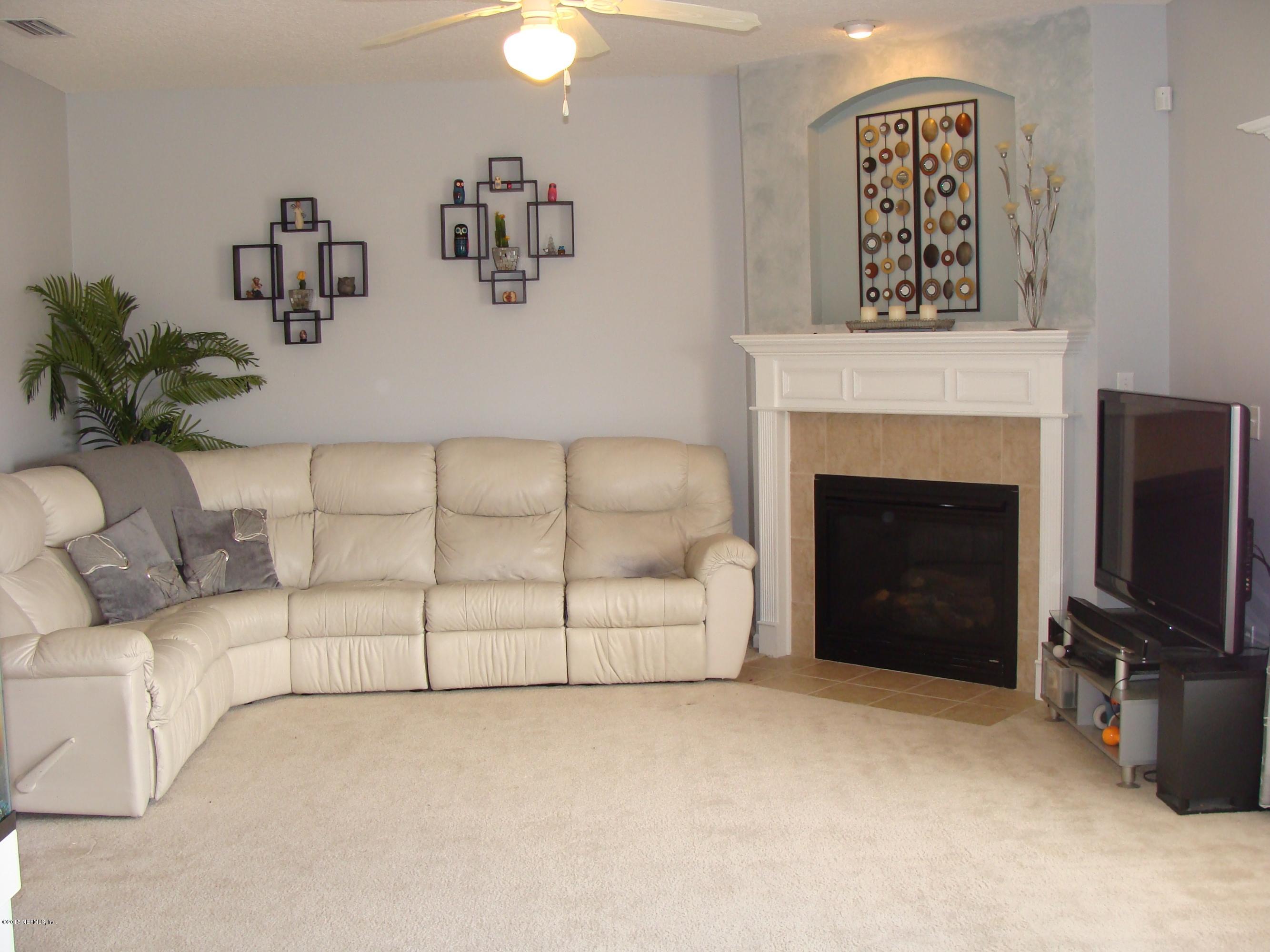 229 Porta Rosa Circle St. Augustine, FL 32092 - Photo 2 of 41 a living room with furniture a flat screen tv and a fireplace