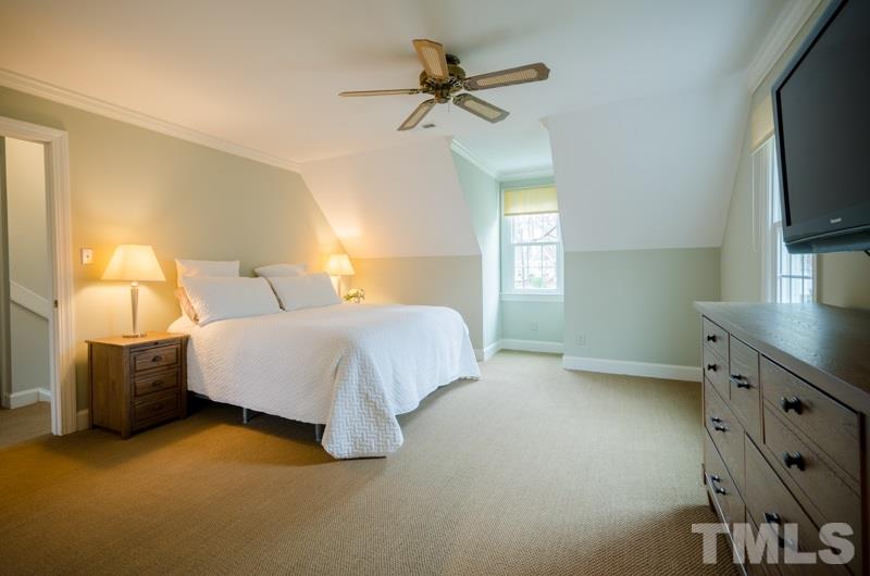 8321 Apple Orchard Way Raleigh, NC 27615 - Photo 14 of 24 a bedroom with a bed and a flat tv screen on dresser