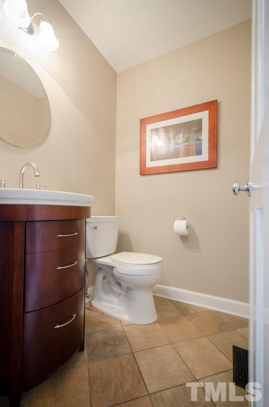 8321 Apple Orchard Way Raleigh, NC 27615 - Photo 4 of 24 a bathroom with a toilet a sink and mirror