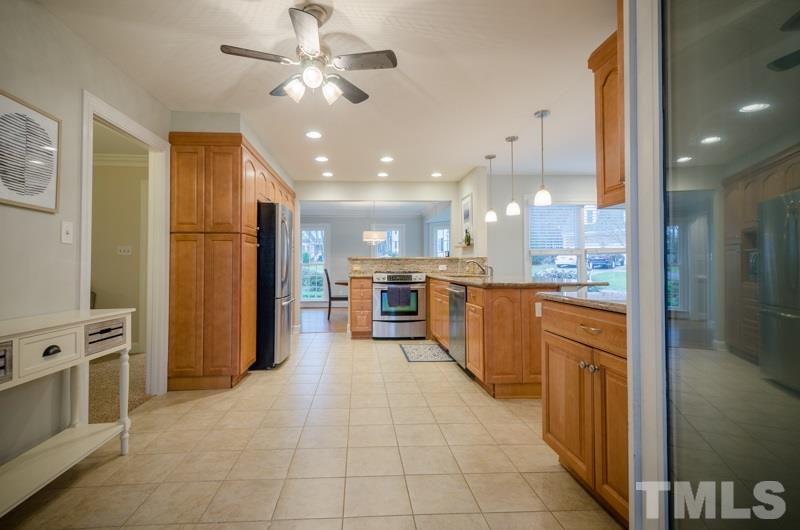 8321 Apple Orchard Way Raleigh, NC 27615 - Photo 7 of 24 a large kitchen with stainless steel appliances kitchen island granite countertop a large counter top and a refrigerator