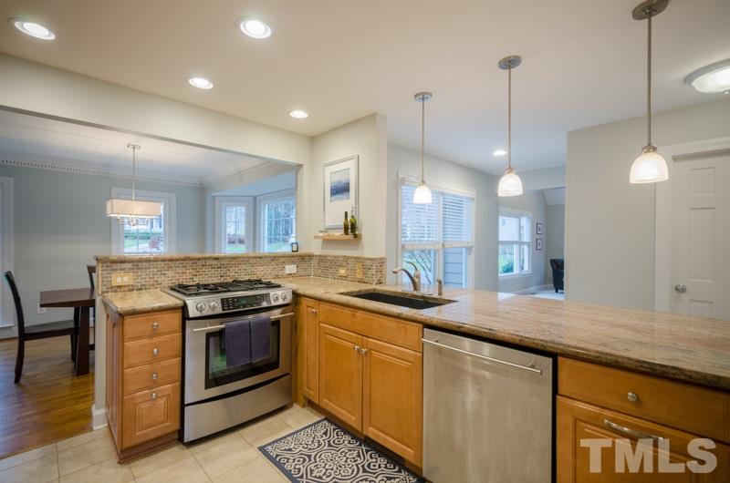 8321 Apple Orchard Way Raleigh, NC 27615 - Photo 9 of 24 a kitchen with stainless steel appliances granite countertop a stove a sink and a wooden floors