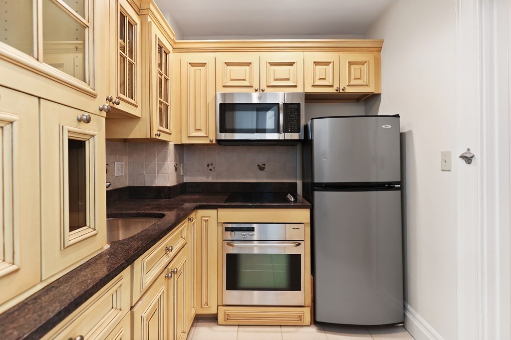 21 Beacon Street, Unit 5D Boston, MA 02108 - Photo 2 of 11 a kitchen with stainless steel appliances a refrigerator and a stove