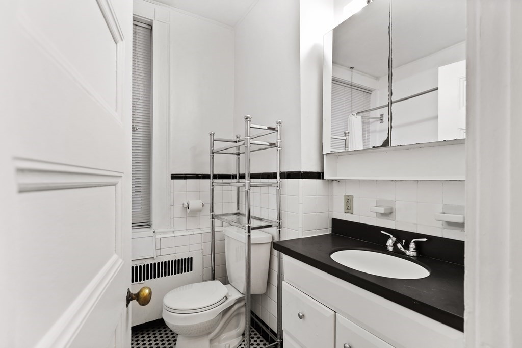 21 Beacon Street, Unit 5D Boston, MA 02108 - Photo 6 of 11 a bathroom with a granite countertop sink toilet a mirror and shower