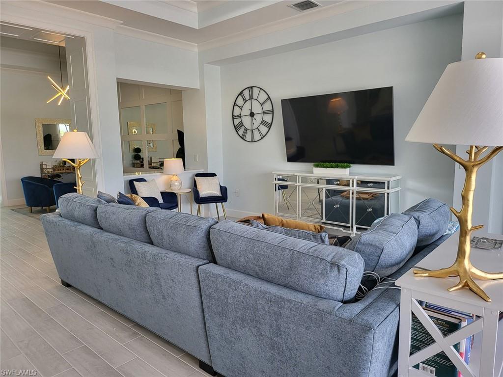 8770 Calypso Court Naples, FL 34113 - Photo 15 of 47 a living room with furniture and a flat screen tv