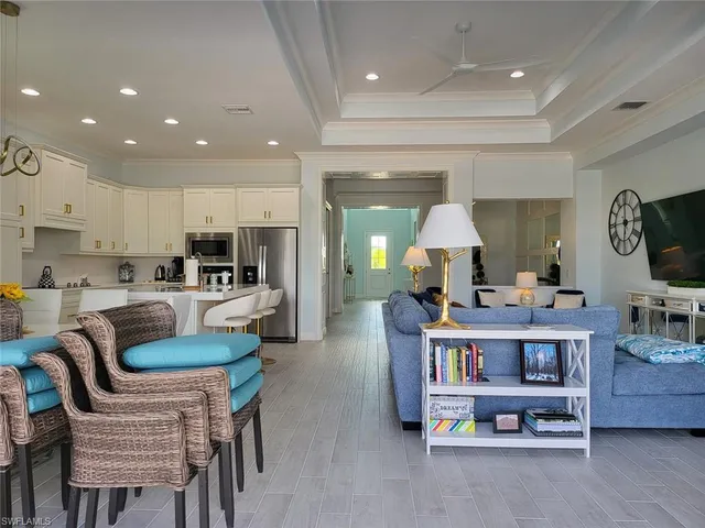 a kitchen with stainless steel appliances granite countertop a table chairs and a refrigerator