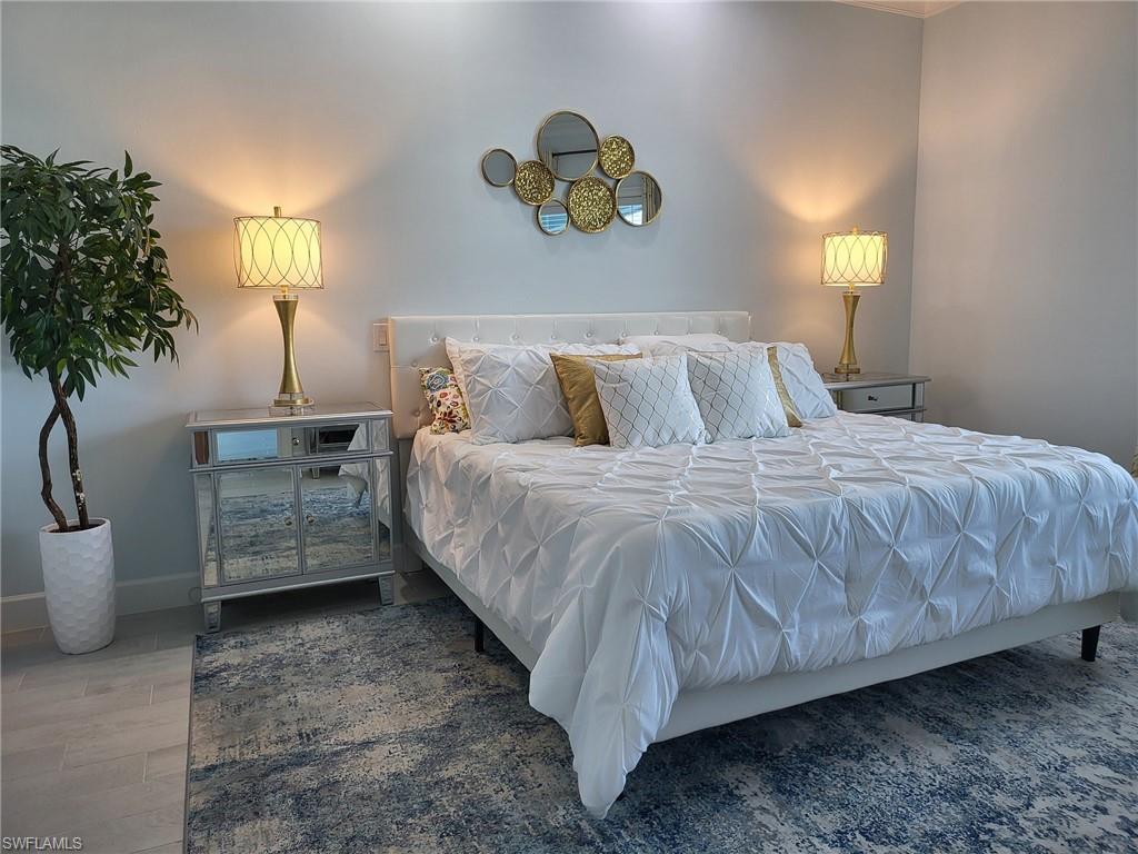 8770 Calypso Court Naples, FL 34113 - Photo 22 of 47 a bedroom with a bed and a lamp