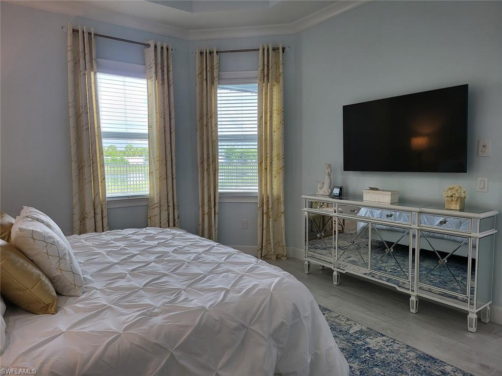 8770 Calypso Court Naples, FL 34113 - Photo 26 of 47 a bedroom with a bed and a flat screen tv