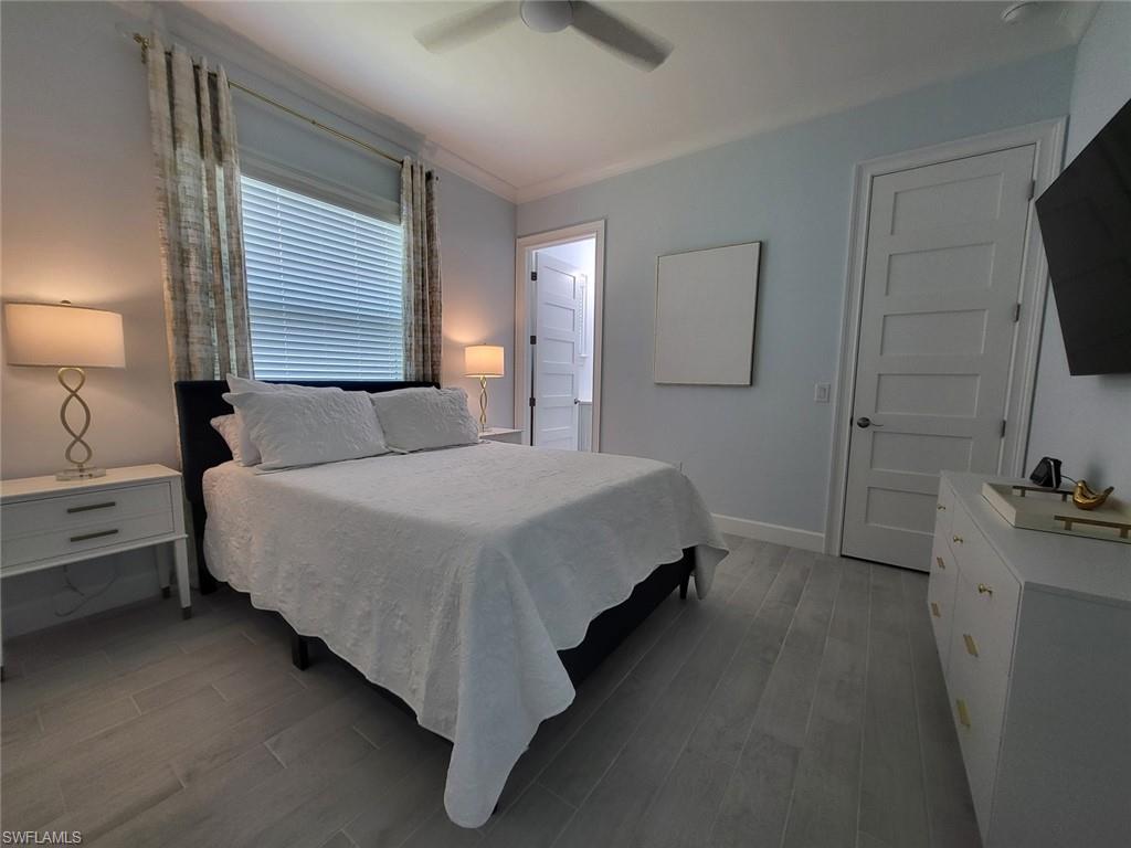 8770 Calypso Court Naples, FL 34113 - Photo 28 of 47 a bedroom with a bed and a flat tv screen on a dresser
