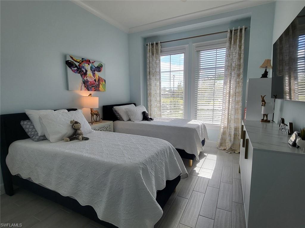 8770 Calypso Court Naples, FL 34113 - Photo 30 of 47 a bed room with a bed window and a television