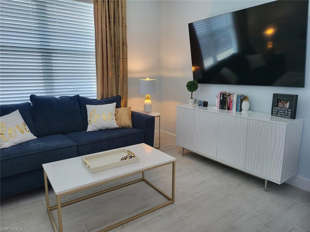 8770 Calypso Court Naples, FL 34113 - Photo 7 of 47 a living room with furniture and a flat screen tv