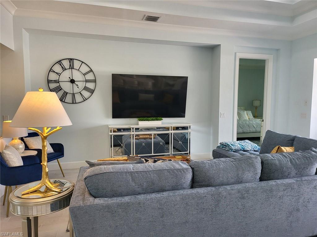 8770 Calypso Court Naples, FL 34113 - Photo 9 of 47 a living room with furniture and a flat screen tv