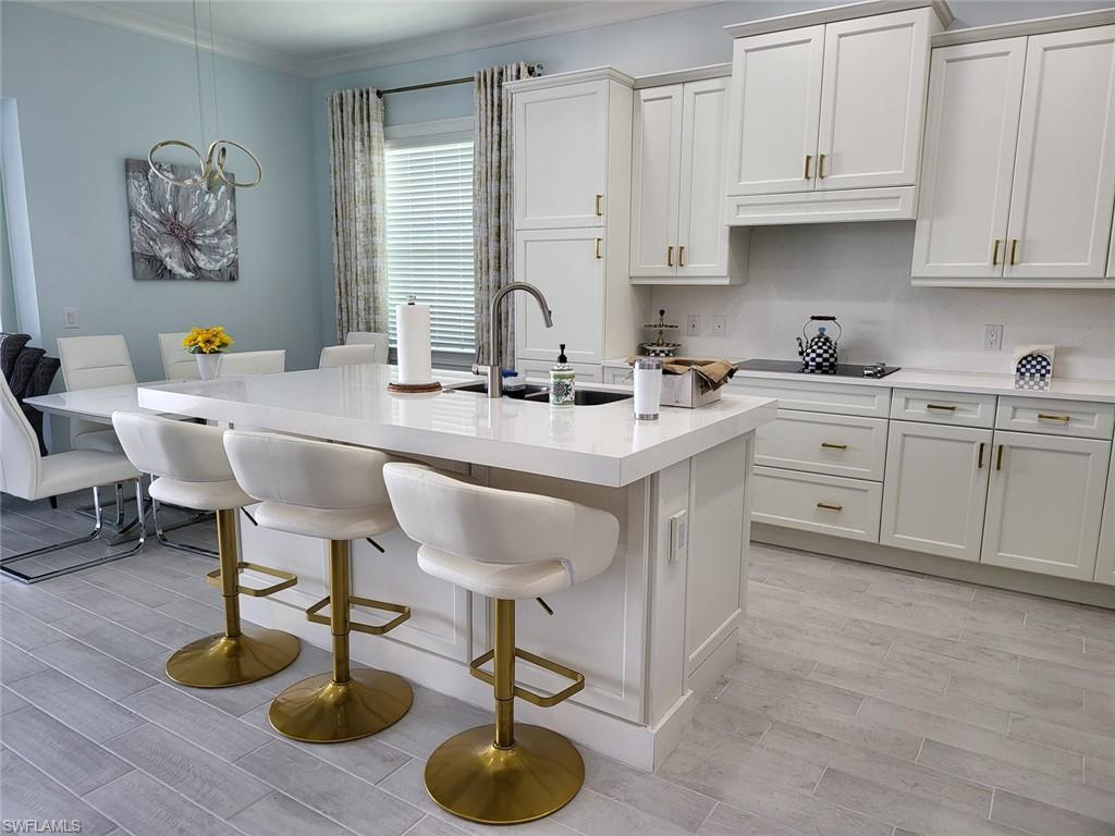 8770 Calypso Court Naples, FL 34113 - Photo 10 of 47 a kitchen with stainless steel appliances granite countertop a sink a stove and a wooden floors