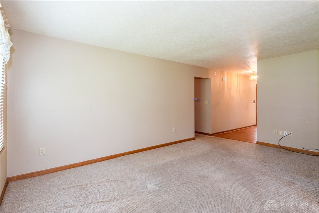 5709 Preble County Line Road Lewisburg, OH 45338 - Photo 15 of 47 An inviting interior space featuring carpet flooring and ample natural light through a window.