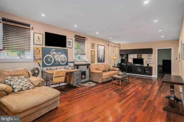 a living room with furniture flat screen tv and wooden floor