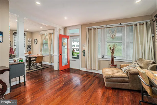 a living room with furniture and a wooden floor