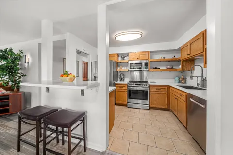 a kitchen with stainless steel appliances kitchen island granite countertop a sink and cabinets