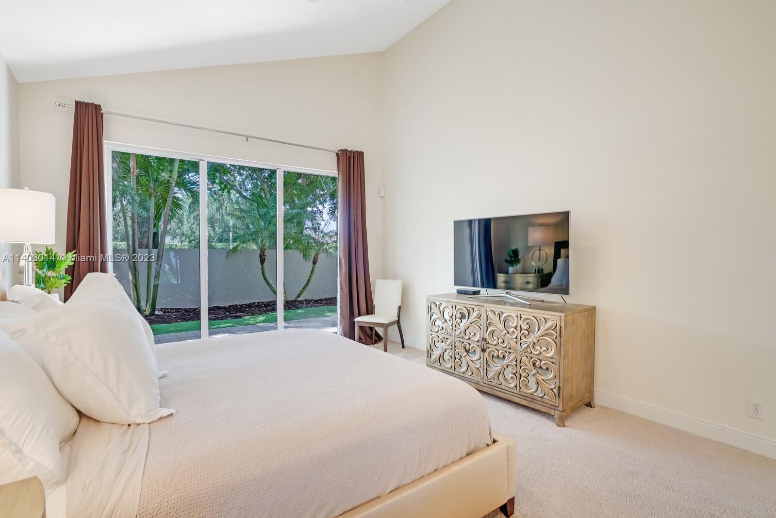 3322 Northwest 53rd Circle Boca Raton, FL 33496 - Photo 24 of 45 a bedroom with a bed and a flat screen tv