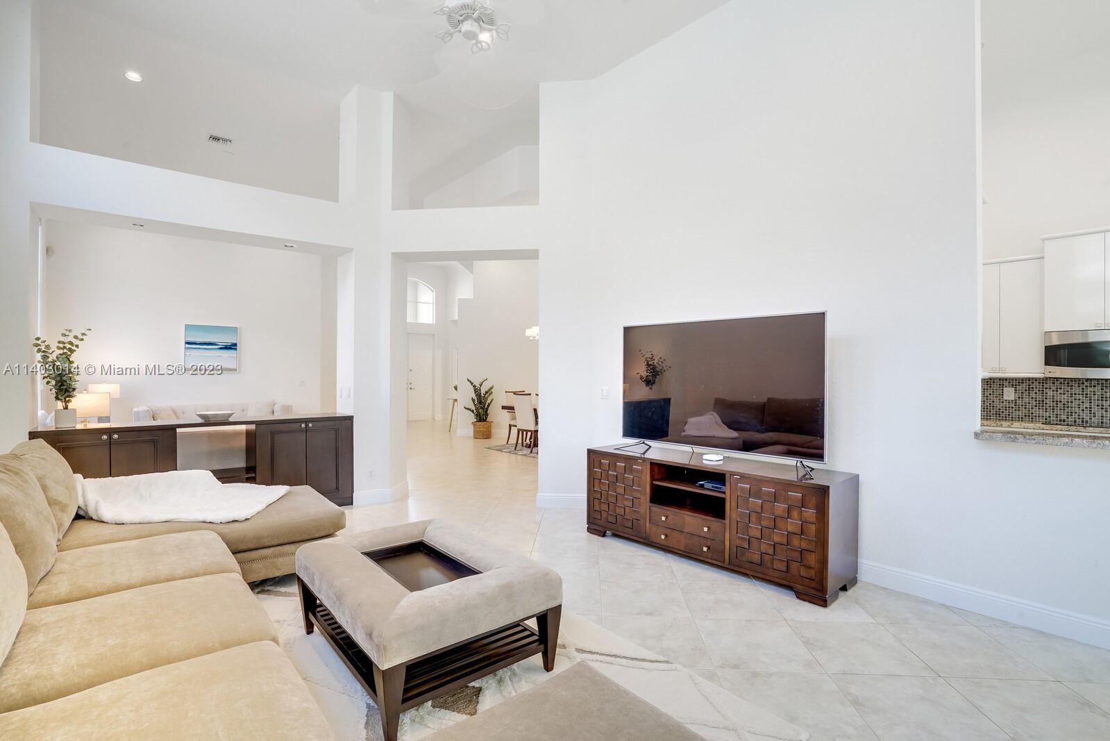3322 Northwest 53rd Circle Boca Raton, FL 33496 - Photo 5 of 45 a living room with furniture and a flat screen tv