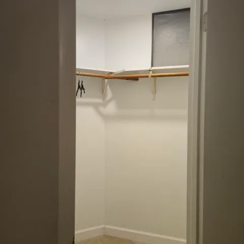 a view of an empty room and chandelier fan