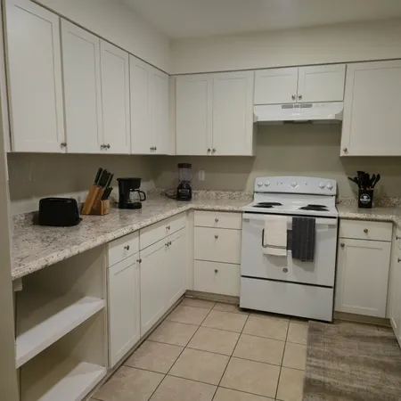 a kitchen with granite countertop white cabinets white stainless steel appliances and sink