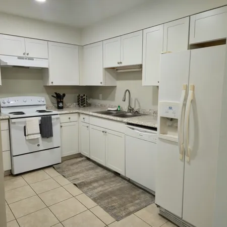 a kitchen with white cabinets and white appliances
