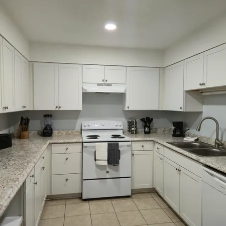 a kitchen with cabinets stainless steel appliances and sink