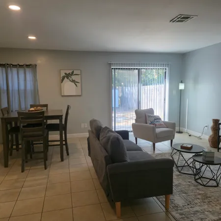 a living room with furniture a desk and chair with windows