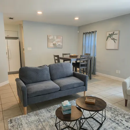 a living room with furniture and a wooden floor