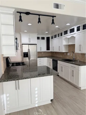 a large kitchen with stainless steel appliances granite countertop a sink and a granite counter tops