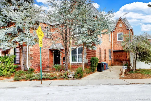 a front view of a house with a yard and potted plants