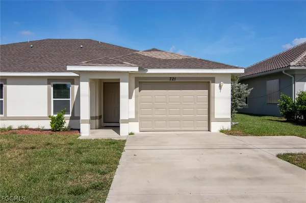 a front view of a house with a yard and garage
