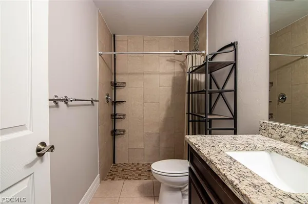 a bathroom with a granite countertop sink toilet and shower