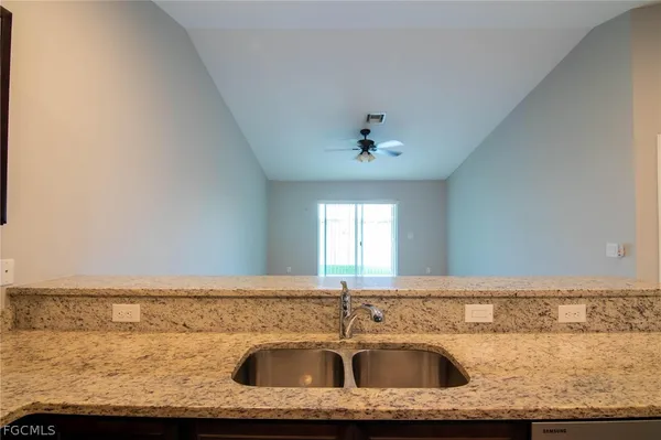 a bathroom with a granite countertop sink and white cabinets