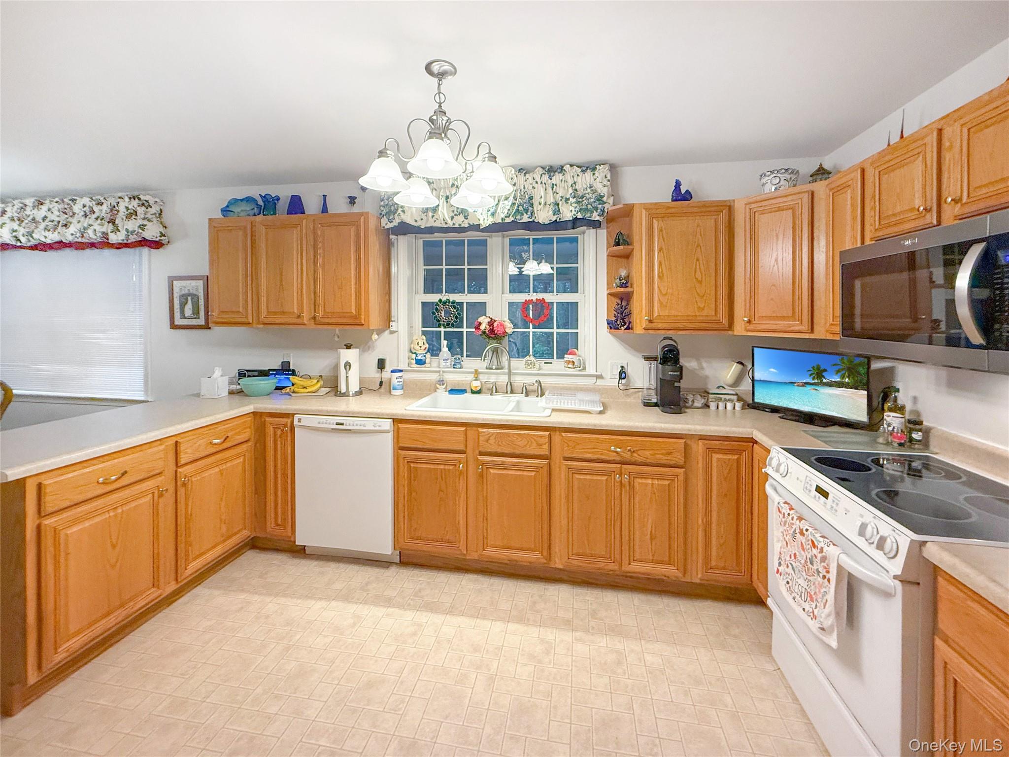 34 Feiertag Road Middletown, NY 10941 - Photo 14 of 28 Kitchen with white appliances, a chandelier, light countertops, and hanging light fixtures