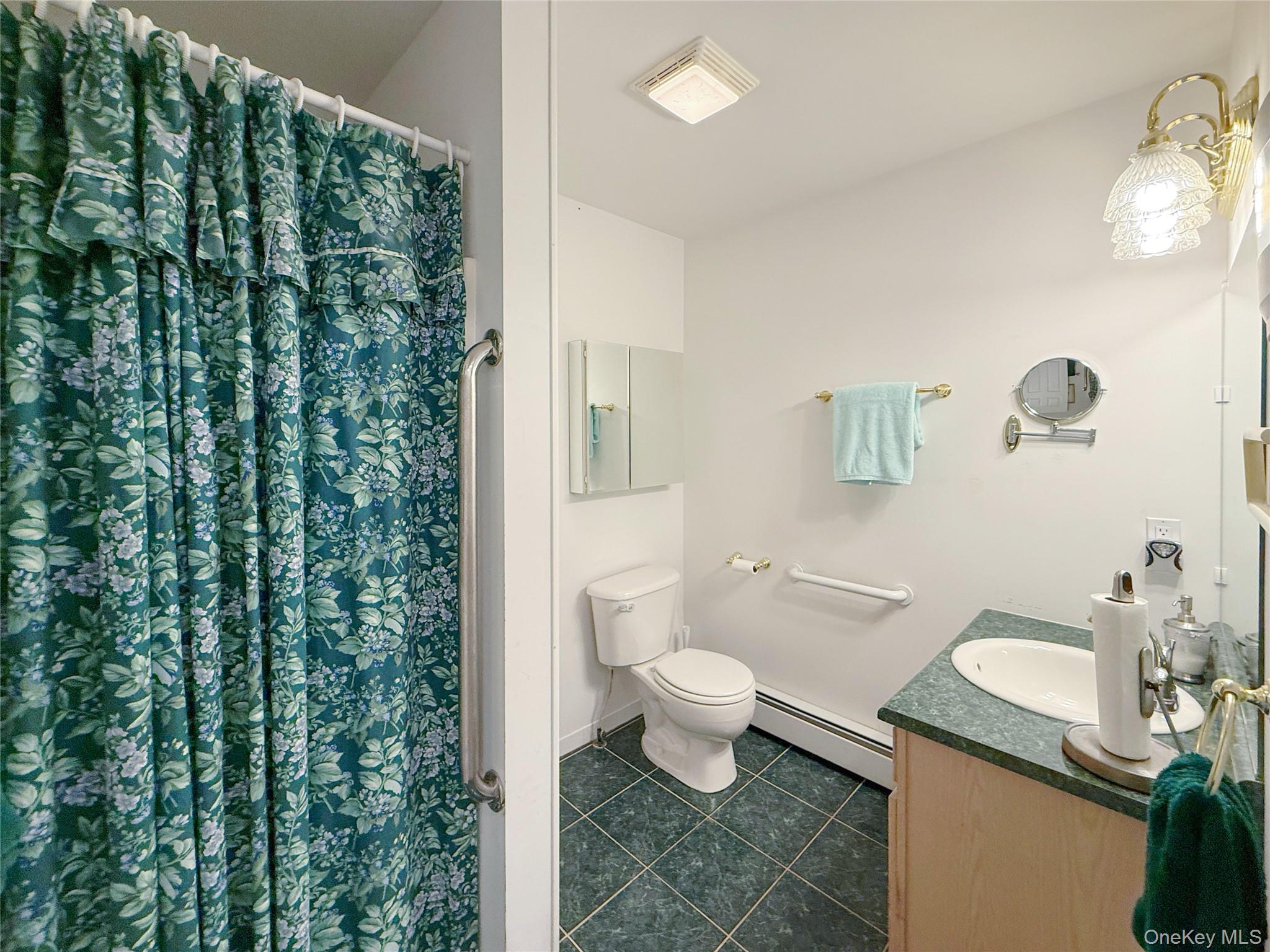 34 Feiertag Road Middletown, NY 10941 - Photo 18 of 28 Bathroom with a baseboard radiator, vanity, tile patterned flooring, and a shower with shower curtain