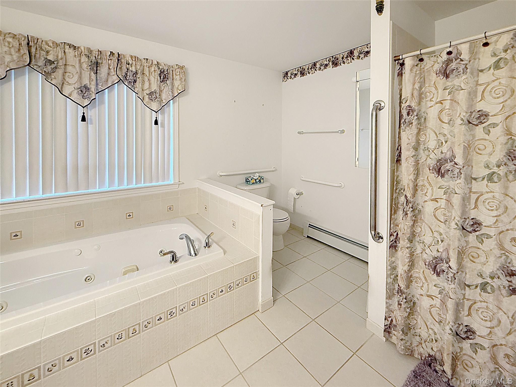 34 Feiertag Road Middletown, NY 10941 - Photo 24 of 28 Bathroom featuring baseboard heating, tile patterned flooring, a jetted tub, and a shower with shower curtain