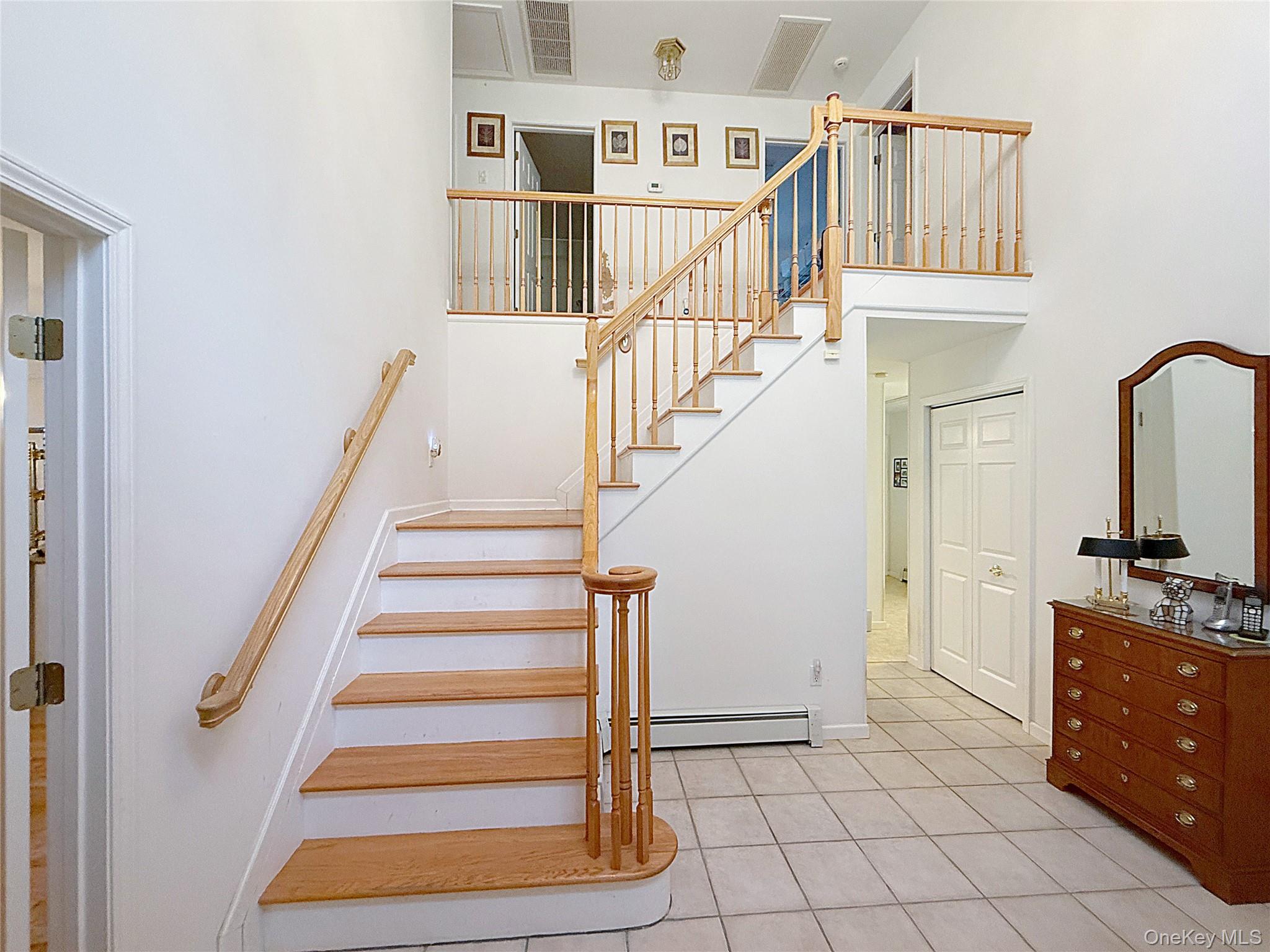 34 Feiertag Road Middletown, NY 10941 - Photo 6 of 28 Stairway featuring tile patterned flooring, a baseboard heating unit, and a high ceiling