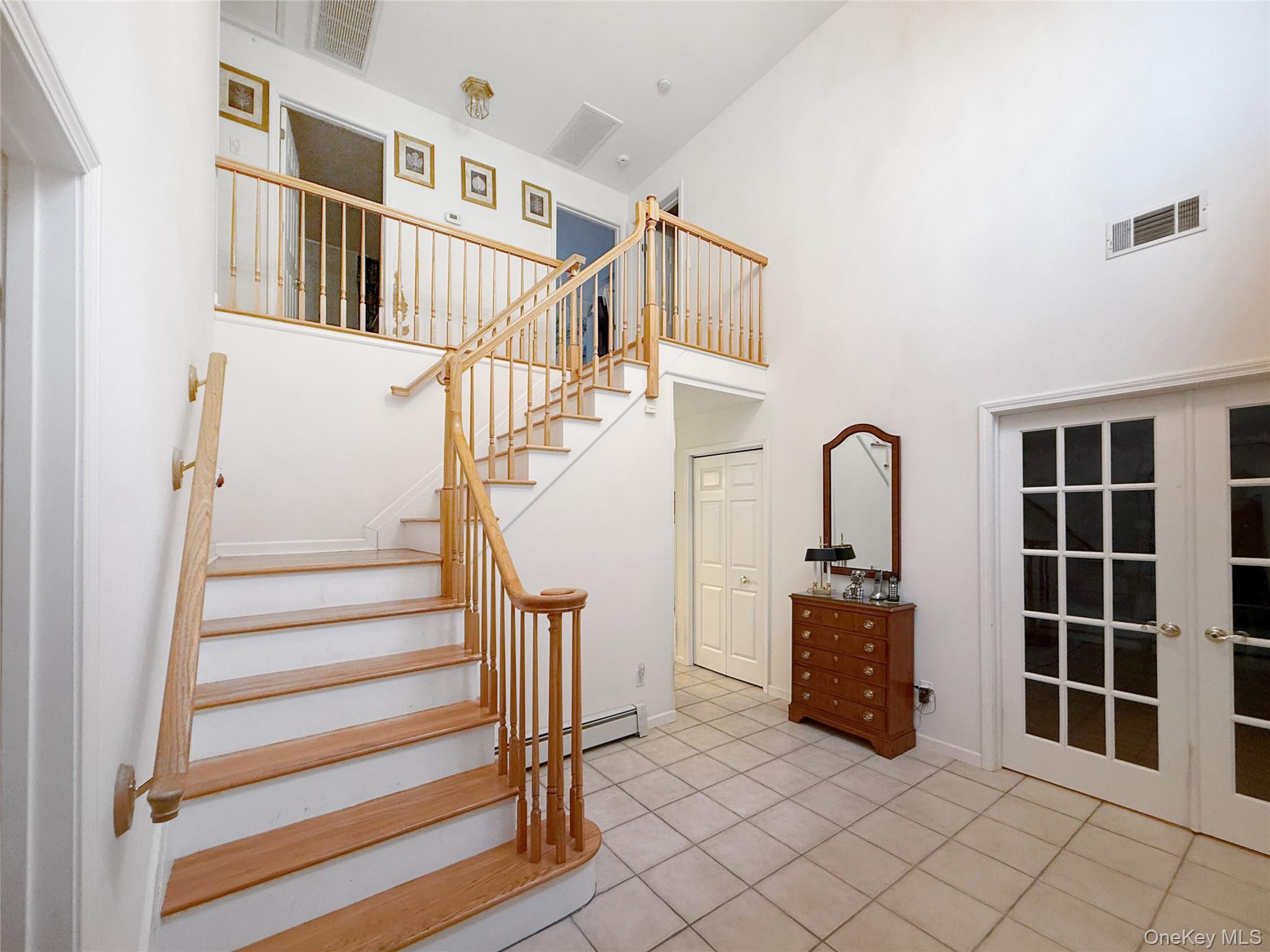34 Feiertag Road Middletown, NY 10941 - Photo 7 of 28 Staircase with a high ceiling, tile patterned floors, and a baseboard radiator