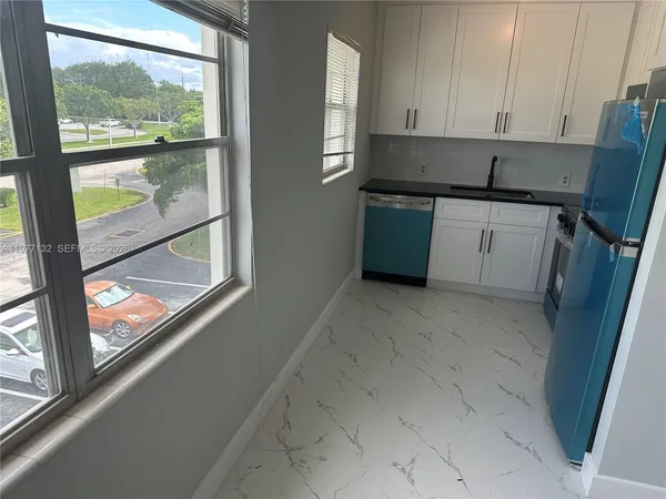 a kitchen with a sink a counter top space and a window