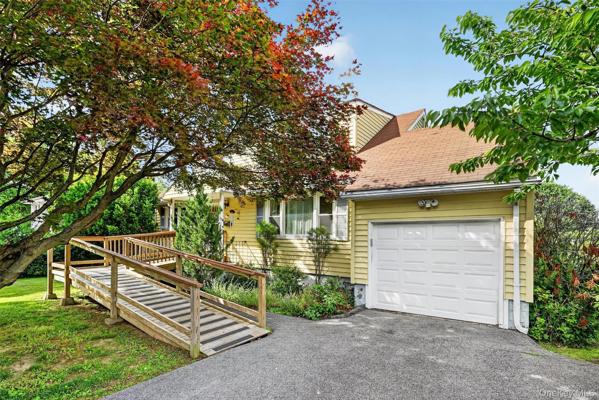 2 Curie Road Cornwall-on-Hudson, NY 12520 - Photo 3 of 37 Yellow siding exterior with white trim, featuring an attached garage with a white panel door