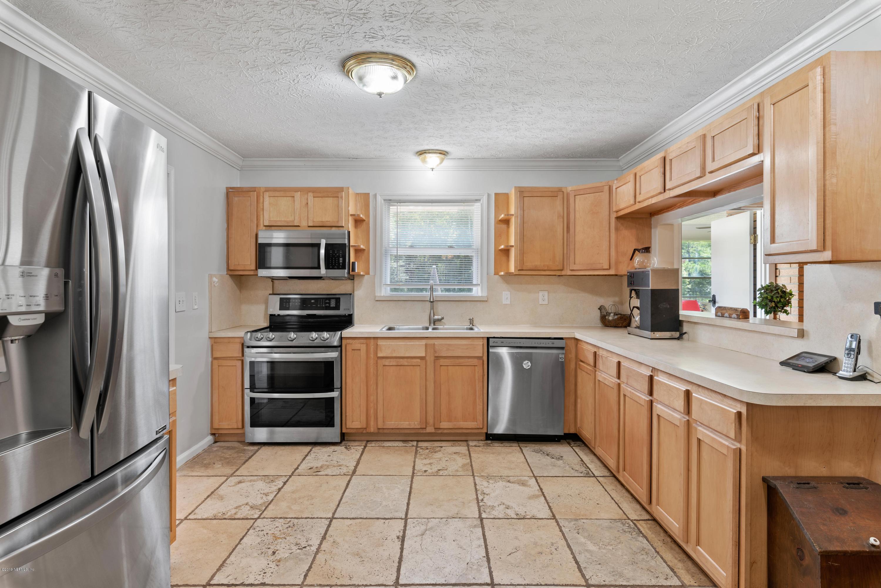 54152 Snyder Road Callahan, FL 32011 - Photo 17 of 39 a kitchen with stainless steel appliances granite countertop a refrigerator sink and stove